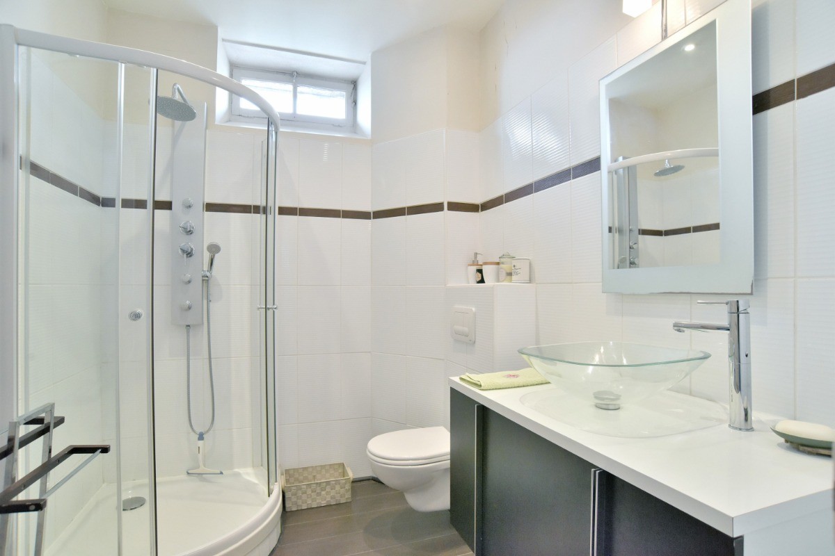 Salle d'eau avec douche grande dimension et WC.