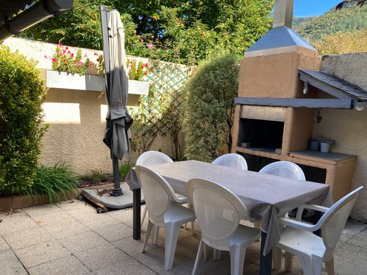 Cour avec salon de jardin et barbecue