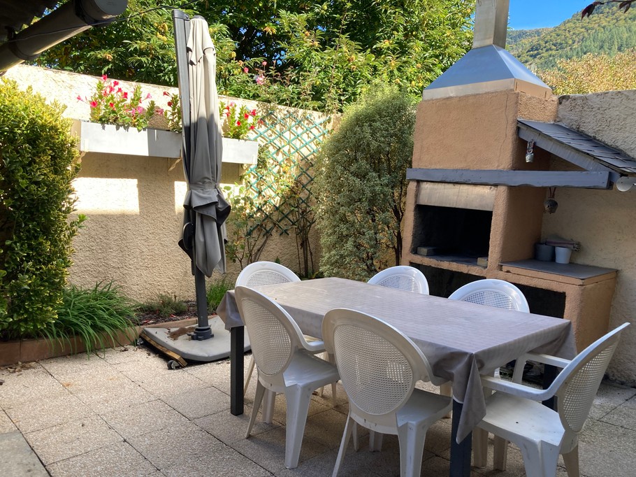 Cour avec salon de jardin et barbecue