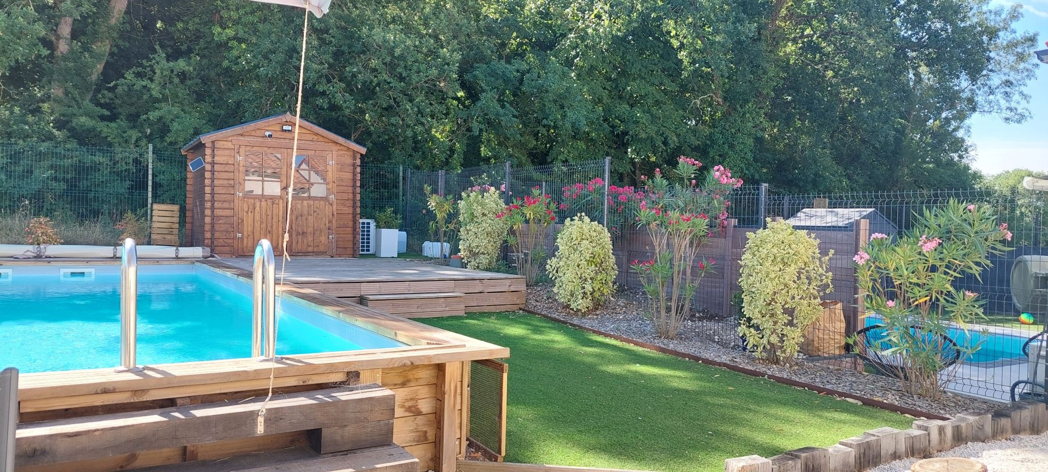 La piscine privée du gite à l'arrière de la maison avec terrasse et jardin