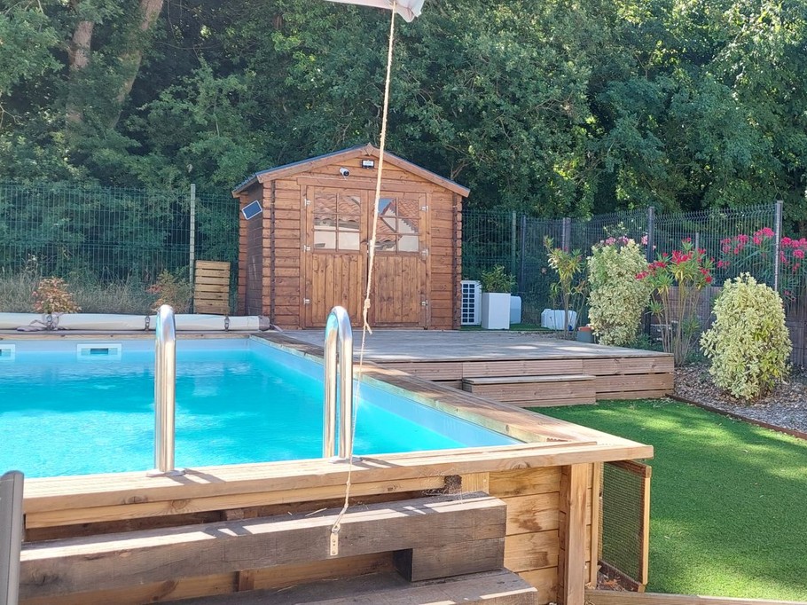 La piscine privée du gite à l'arrière de la maison avec terrasse et jardin