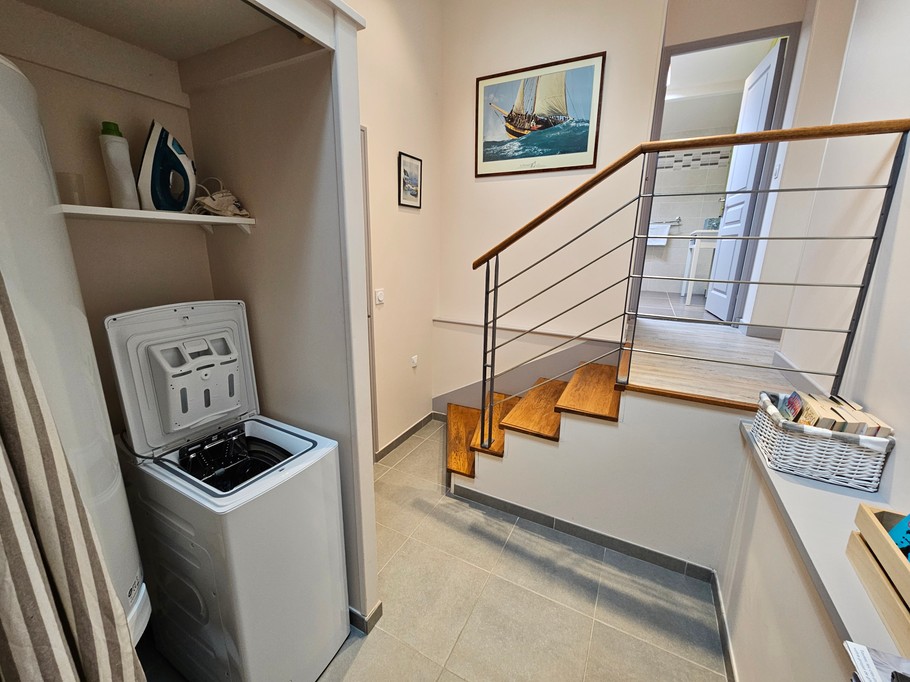 Washing machine in the entrance hall, away from the bedrooms. Other cleaning accessories are available in the private garage.