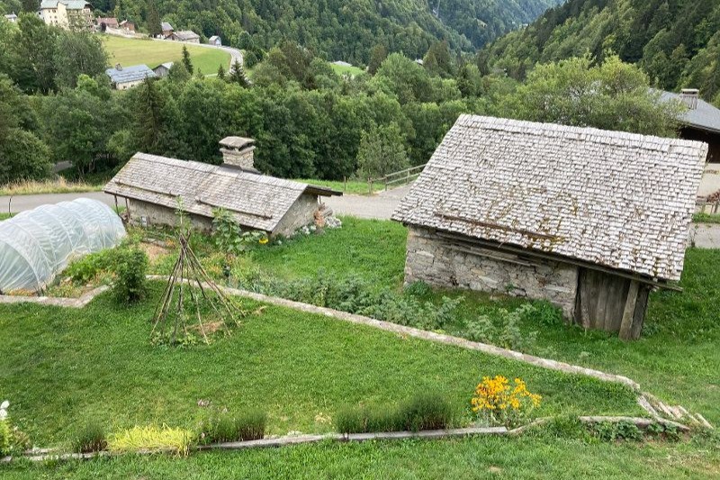 depuis le chalet vue sur le four à pain et le grenier et sur le village et la vallée
