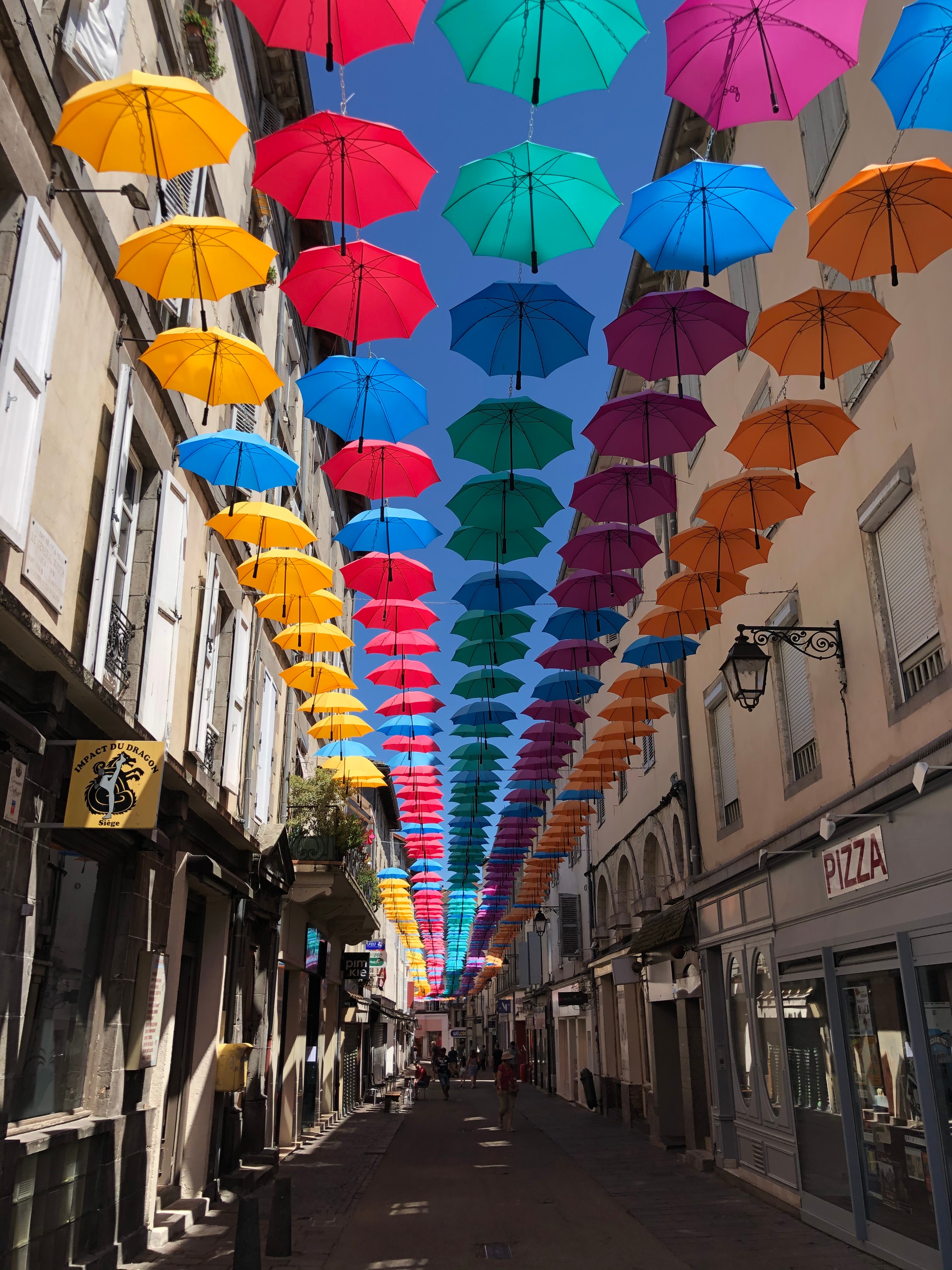 Vue de la rue d’Aurillac avec les célèbres parapluies suspendus et ambiance festive