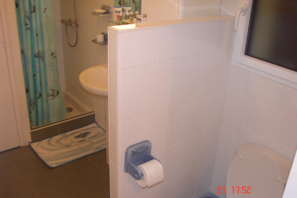 Salle d'eau avec lave linge et  WC isolé par petite séparation.