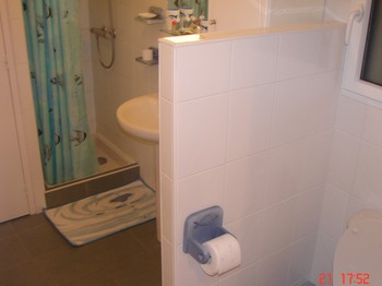 Salle d'eau avec lave linge et  WC isolé par petite séparation.