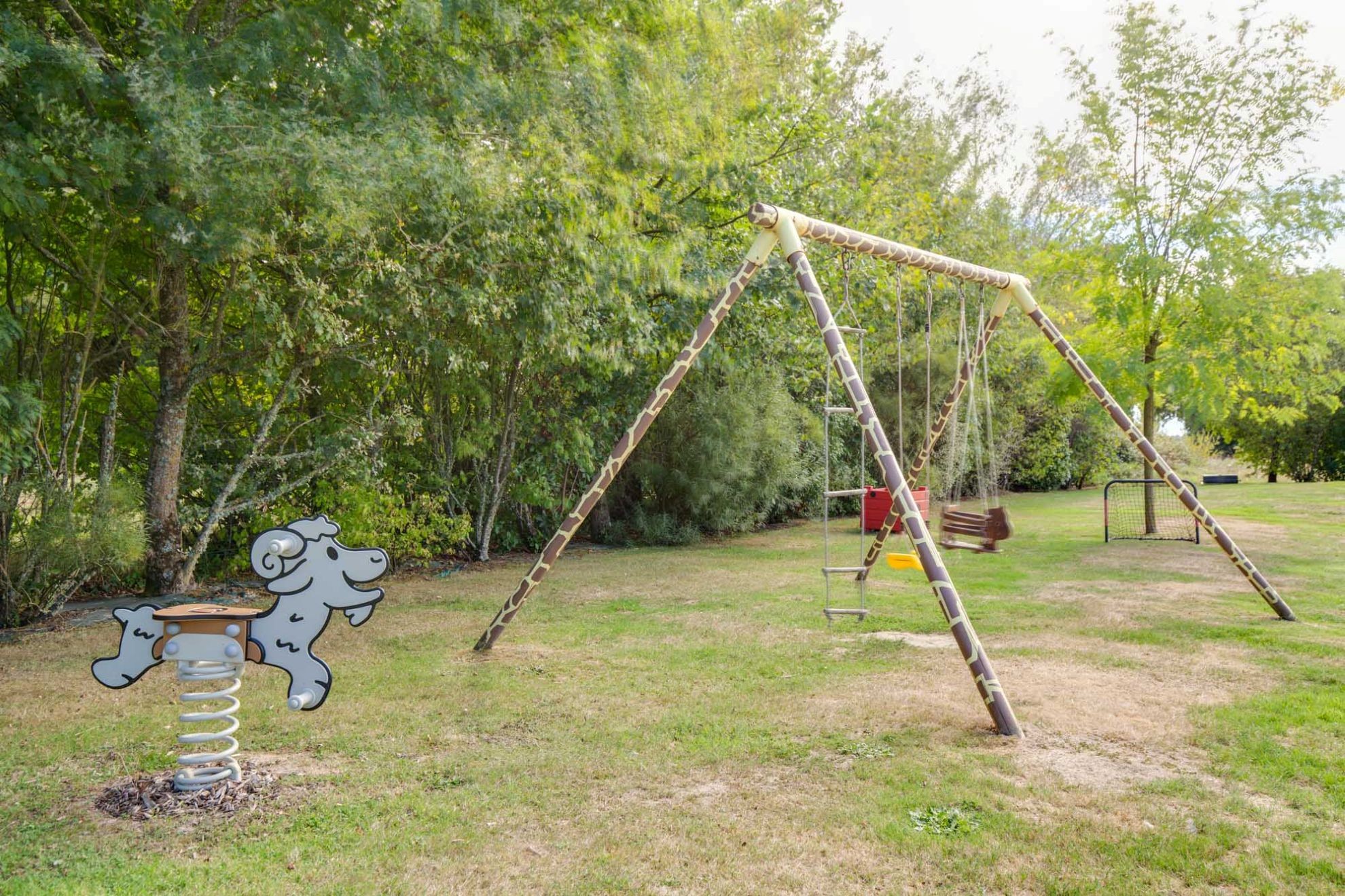 Parc de loisirs avec terrain de pétanque, terrain de volley, balançoire, jeu sur ressort, table de ping pong...
