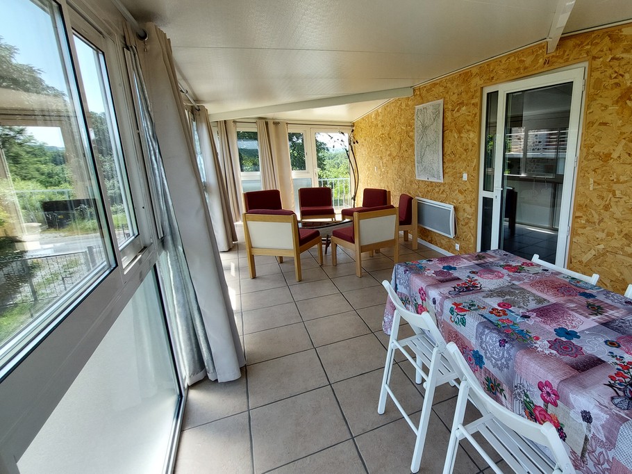 Coin repas dans la véranda du gîte Lilas à La Villa aux Fleurs