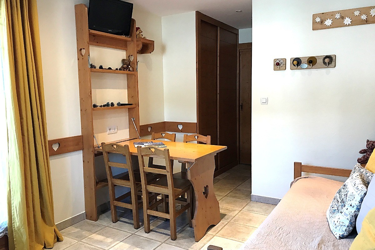 vue de la pièce principale avec le coin repas, location Casareva, tv, accès direct au jardin en été.