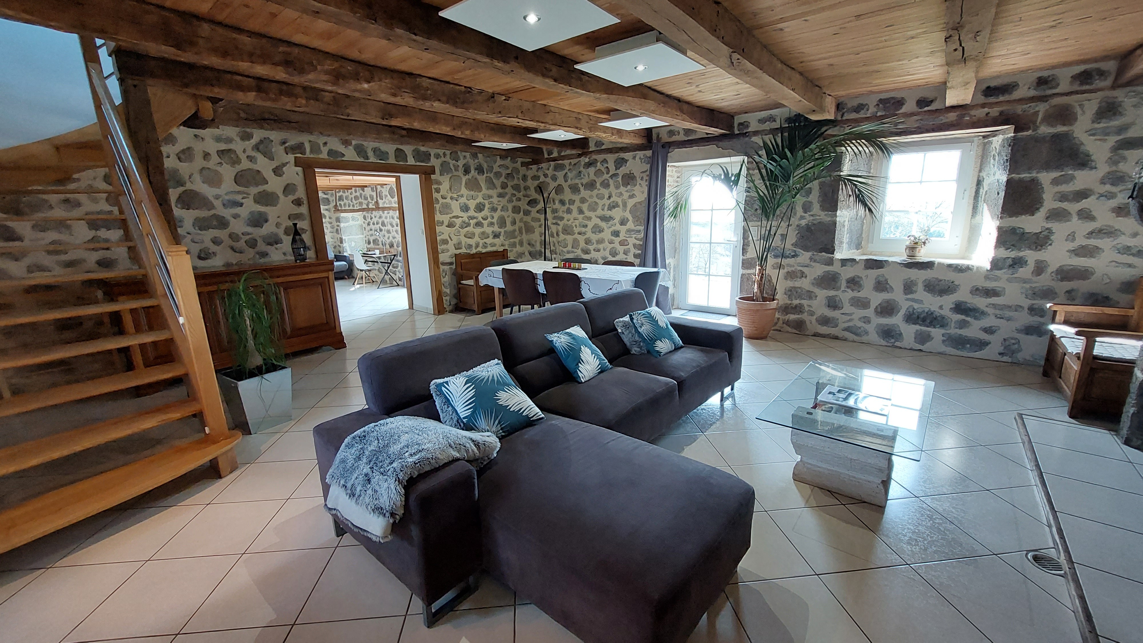 Large stone living room with exposed beams Auvergne house Cantal