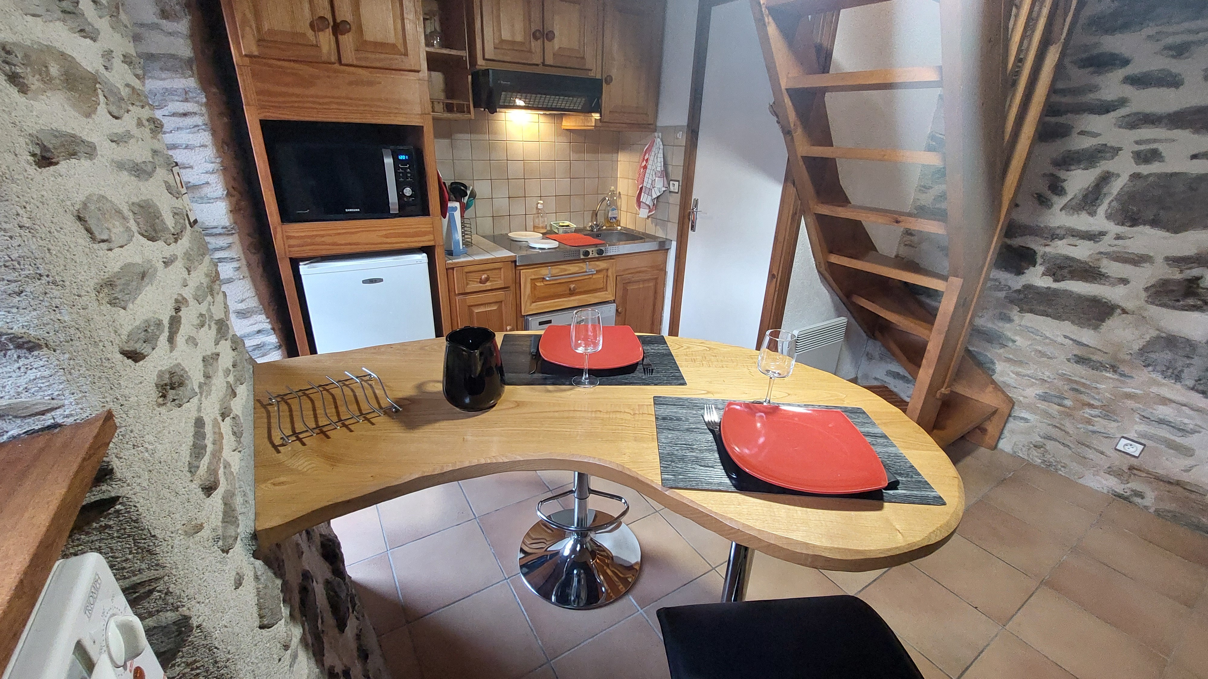 Pièce de vie du micro-gîte avec coin cuisine équipé, ambiance chaleureuse et fonctionnelle