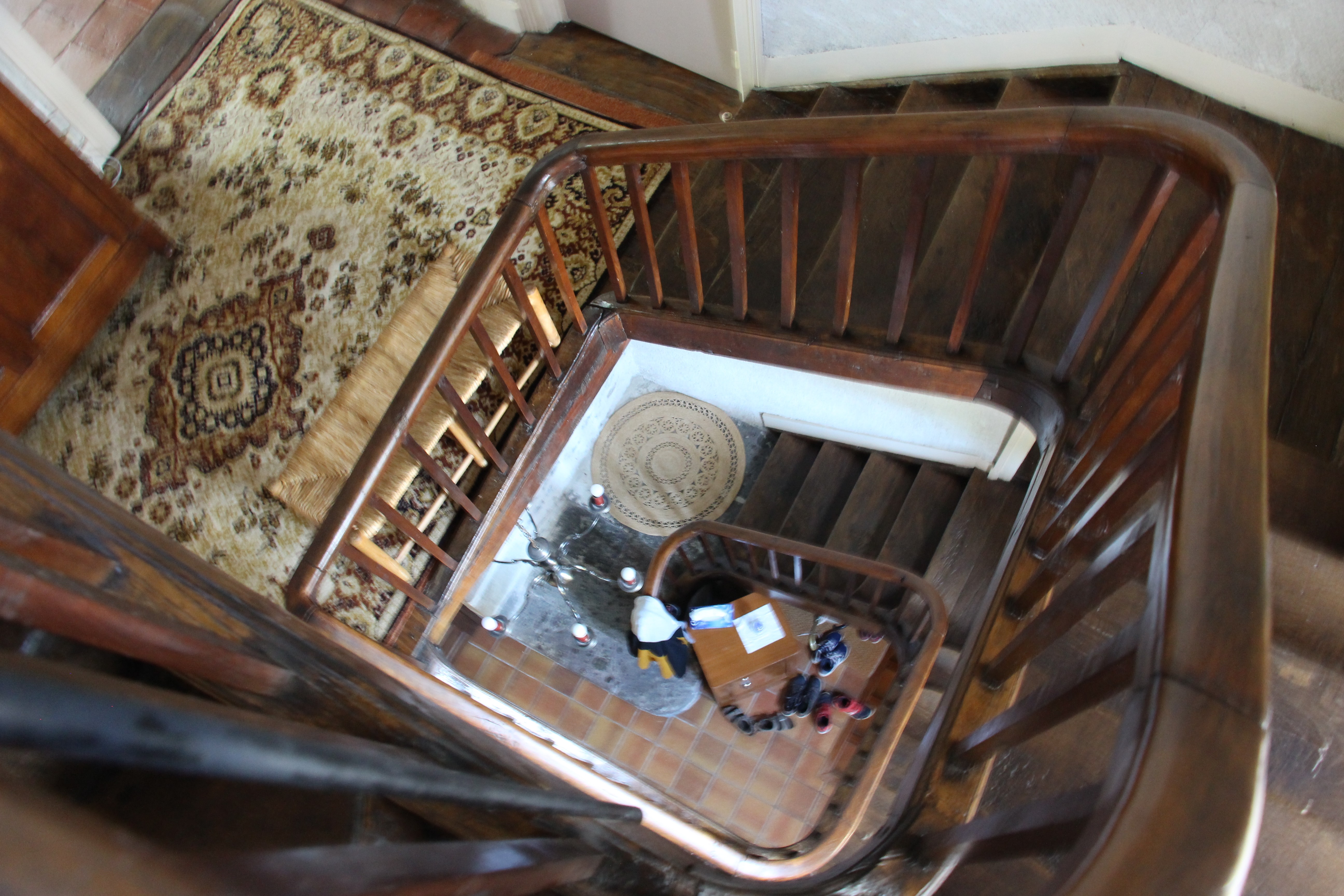 Escalier en bois vu du haut, mettant en valeur le style architectural du XVIIIe siècle