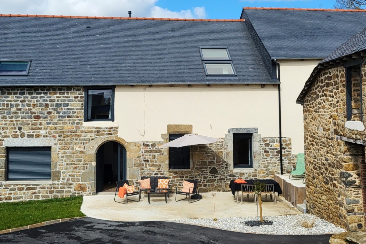 Façade et terrasse ensoleillée du gîte. Stationnement privatif
