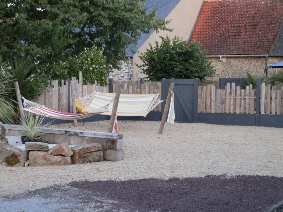 Façade côté cour avec terrasses ombragées. aire de relaxation avec hamacs.