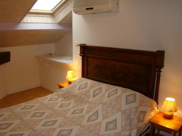 Chambre violette climatisée avec lit de 140 cm et point d'eau