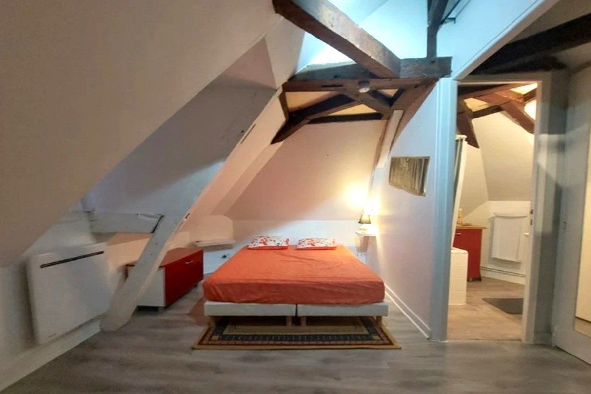 Coin cuisine et bureau dans la pièce de vie avec poutres apparentes. ©M. Pellerin