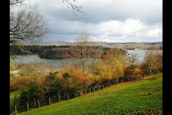 Vue panoramique sur le lac de Saint-Étienne Cantalès depuis le jardin du gîte