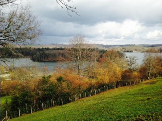 Vue panoramique sur le lac de Saint-Étienne Cantalès depuis le jardin du gîte