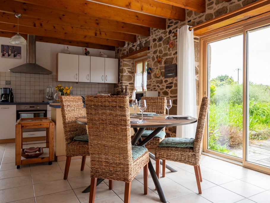 Pièce de vie avec espace repas et cuisine en arrière-plan