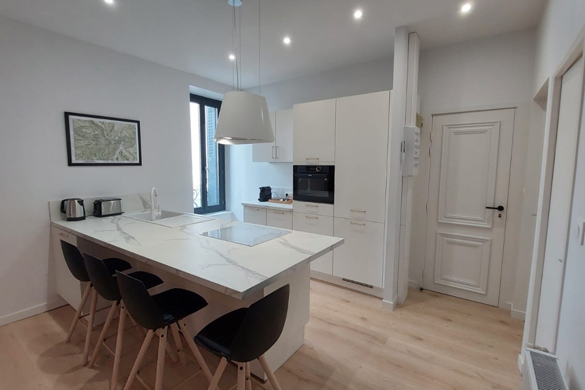 Espace repas convivial avec îlot central et chaises hautes