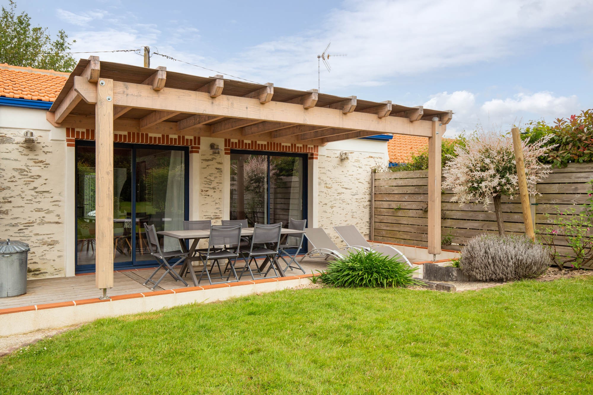 Jardin privatif avec pergola, hamac, salon de jardin, bain de soleil, barbecue et fils à linge.