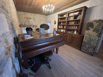 Au 1er étage sur le palier, le piano familial et la bibliothèque de la Maison Gareshé en Charente maritime