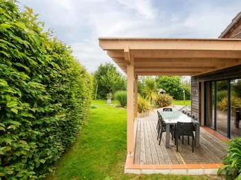 Jardin privatif avec terrasse, transats, salon de jardin, pergola, barbecue et fils à linge.