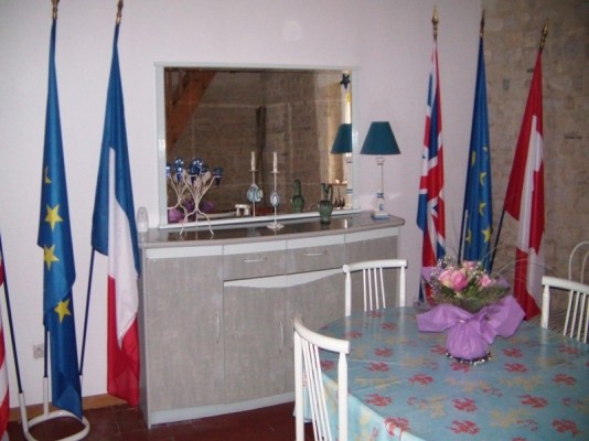 un salle à manger avec un mur en pierre et une décoration mémoire , TV wifi + meubles de rangement pour la vaisselles