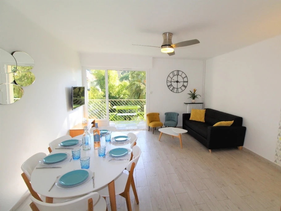 Séjour avec balcon et vue sur jardin méditerranéen.