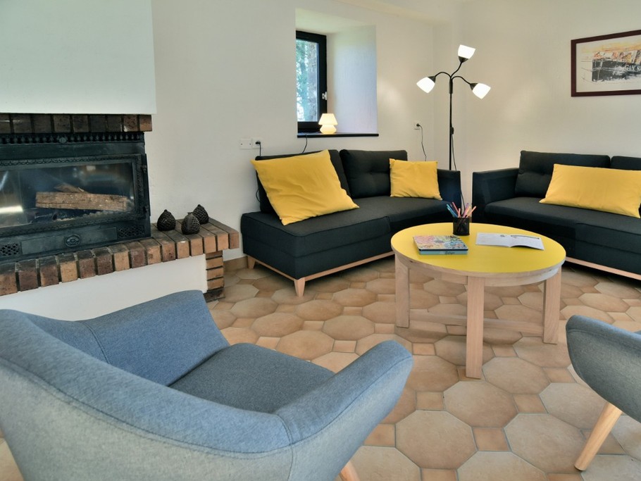 Grande pièce de vie au RDC avec coin salon et sa cheminée.