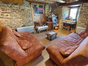 Salon cosy avec fauteuils et décoration authentique, parfait pour un moment de détente en maison d'hôtes