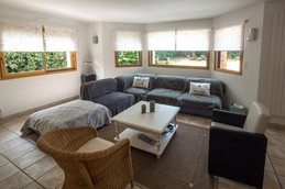 Grande pièce de vie lumineuse avec accès jardin. Coin salon.