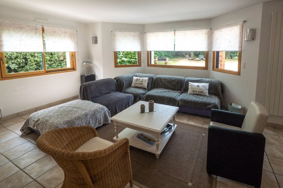 Grande pièce de vie lumineuse avec accès jardin. Coin salon.