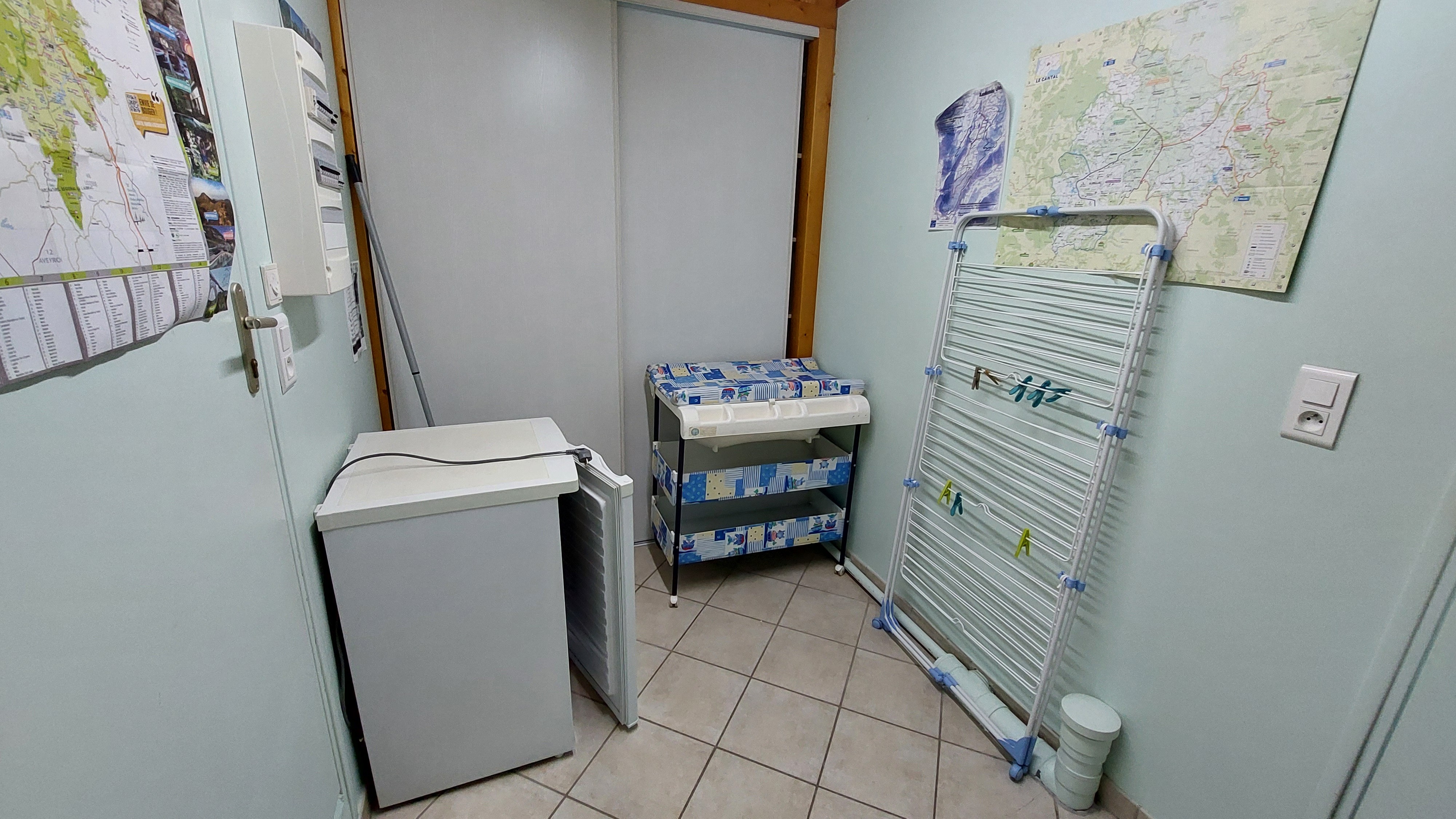 laundry room with storage space and drying rack in gîte in the heart of the Cantal region