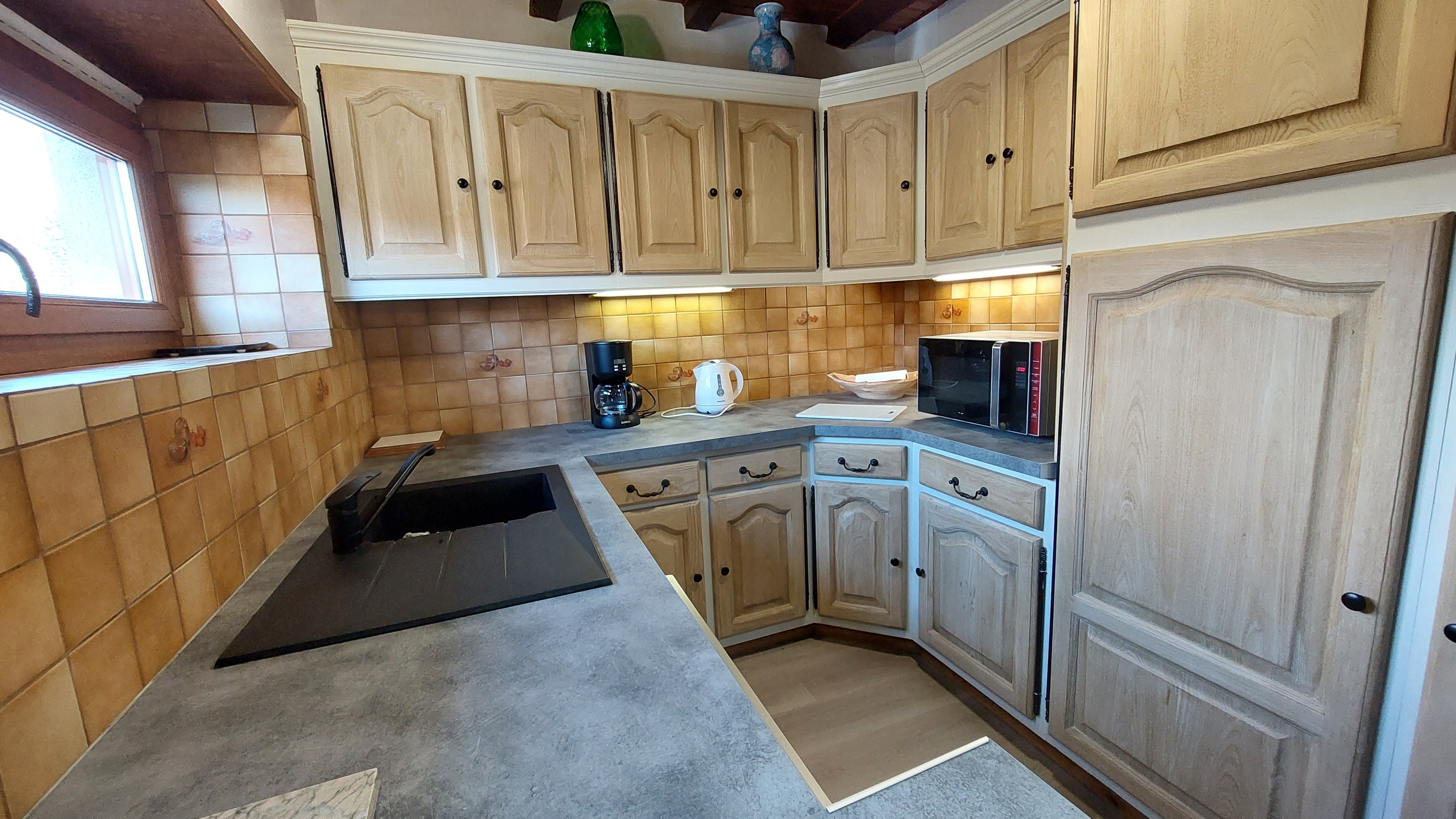 Functional kitchen with sink, coffee maker and wooden cupboards