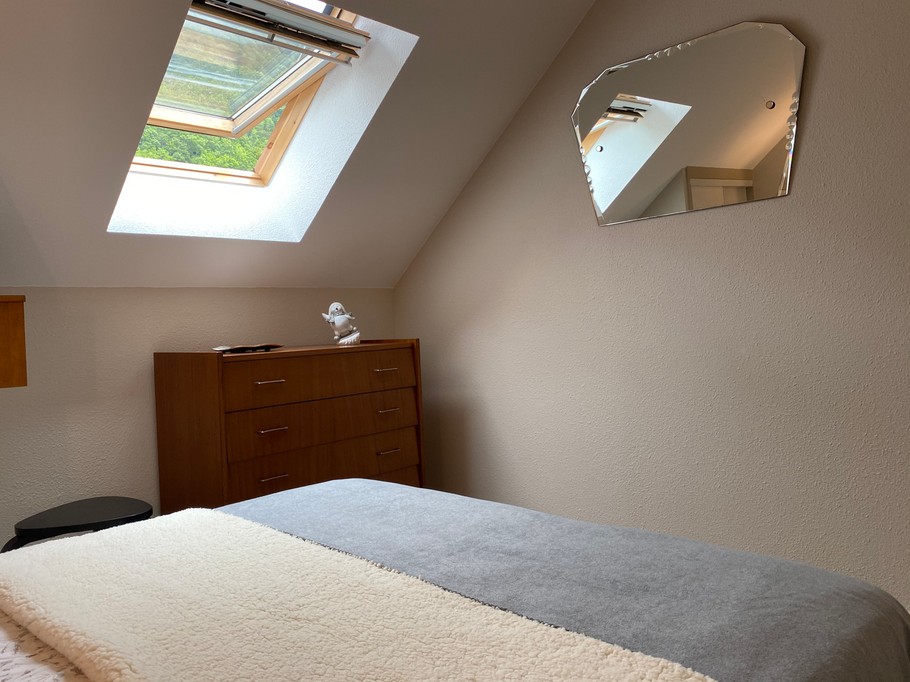 Chambre parents avec fenêtre velux équipée d'un rideau occultant