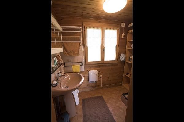 Salle d'eau à l' étage équipée d'un lavabo, d'une douche et  d'une armoire de toilette et d'une étagère de rangement.