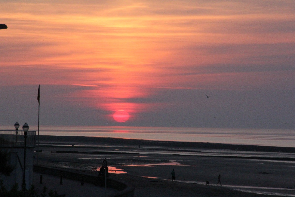 C'est bien en face du gîte surtout en juin et juillet, après il faut sortir dans le jardin ou sur la digue pour le voir se coucher sur la mer. Mais les levers sont aussi beaux ! (là c'est marée basse... bientôt l'heure des feux d'artifices.