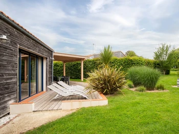 Jardin privatif avec terrasse, transats, salon de jardin, pergola, barbecue et fils à linge.