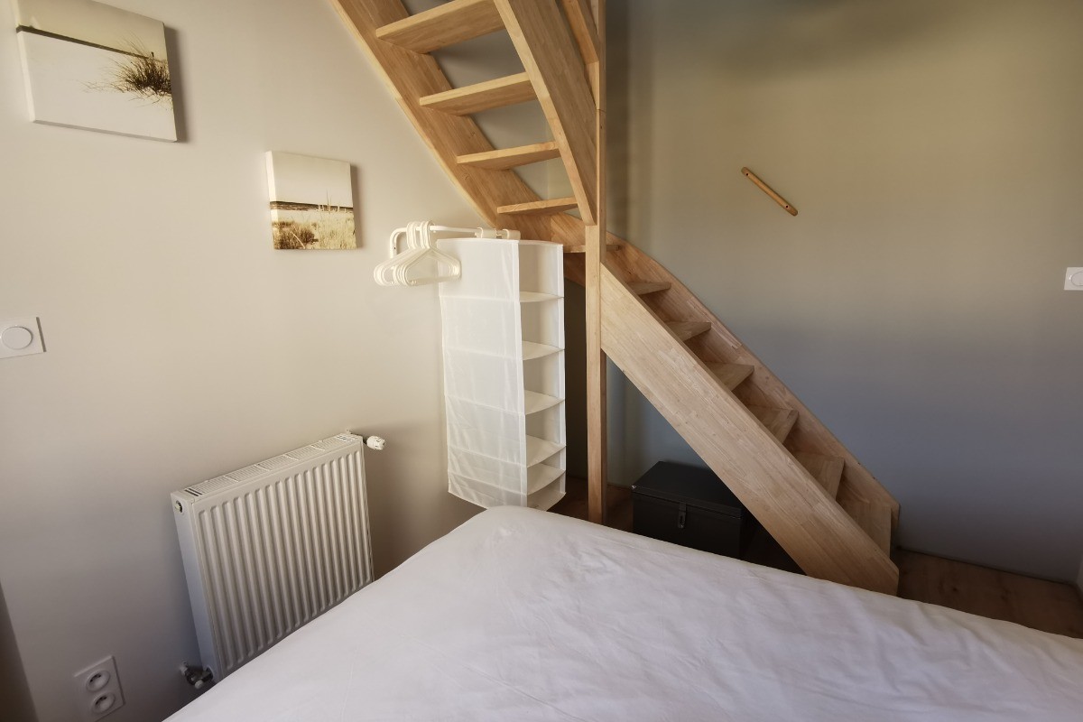 Chambre avec lit 140 et accès aux combles.