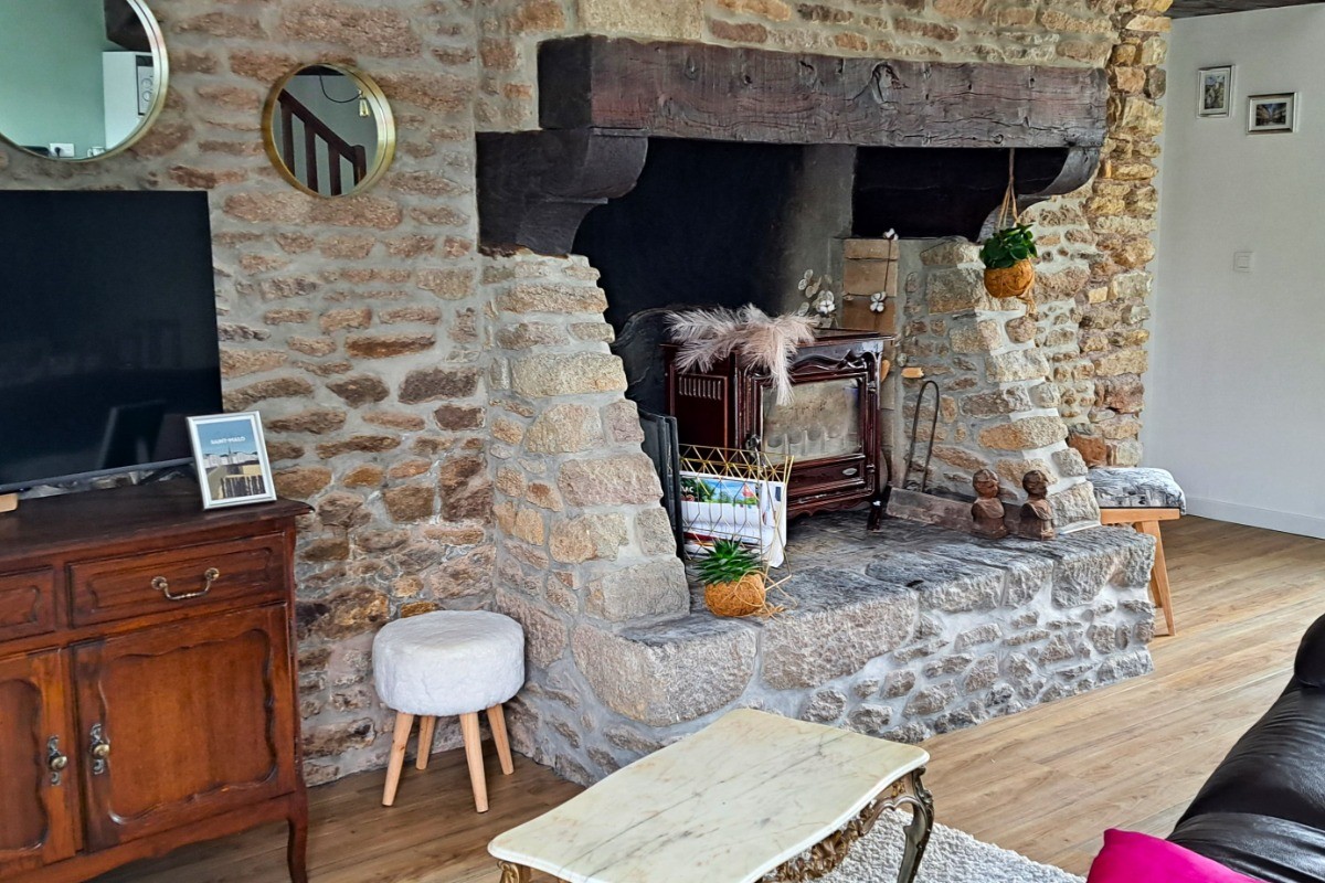 Grande pièce de vie au rez-de-chaussée avec espace cuisine ouverte, séjour et salon (cheminée décorative). Accès direct à la terrasse et au jardin clos par la baie vitrée.