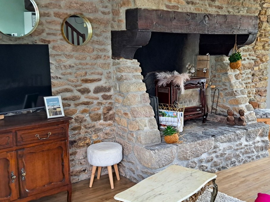 Grande pièce de vie au rez-de-chaussée avec espace cuisine ouverte, séjour et salon (cheminée décorative). Accès direct à la terrasse et au jardin clos par la baie vitrée.