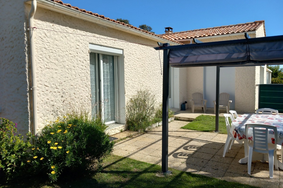 Terrasse et porte fenêtre de la chambre vues depuis le parking