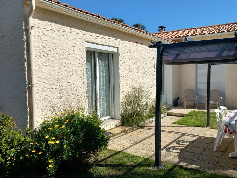 Terrasse et porte fenêtre de la chambre vues depuis le parking