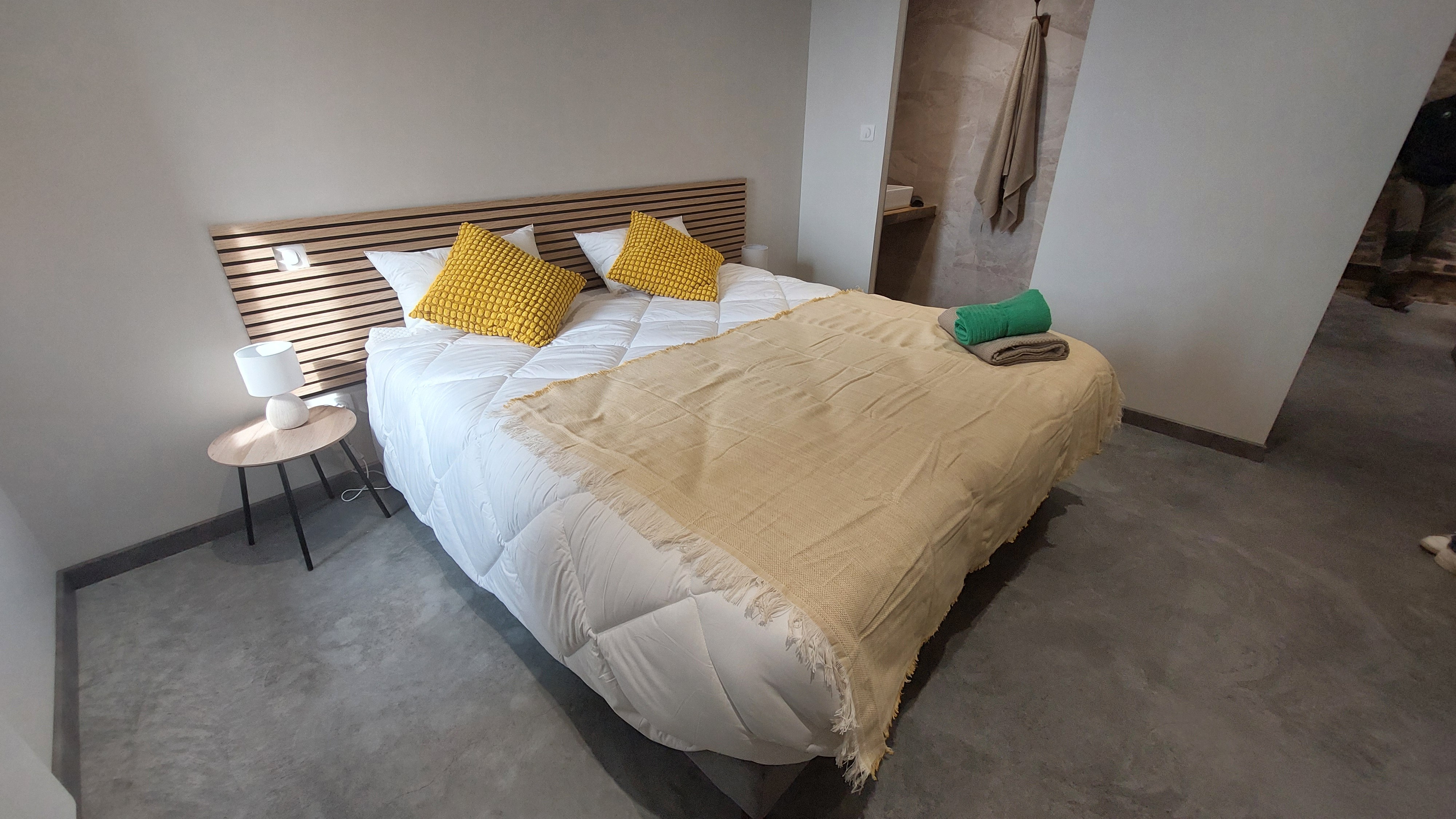 Chambre jaune du gîte avec lit double modulable, atmosphère lumineuse et décoration harmonieuse.
