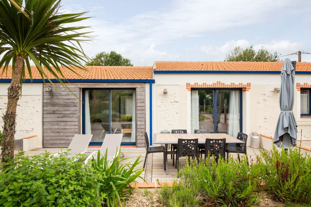 Jardin privatif avec terrasse, salon de jardin, transats, parasol, barbecue et fils à linge.