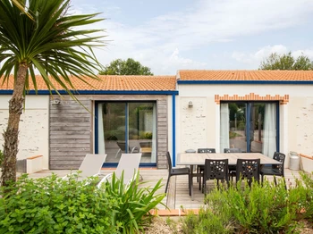 Jardin privatif avec terrasse, salon de jardin, transats, parasol, barbecue et fils à linge.