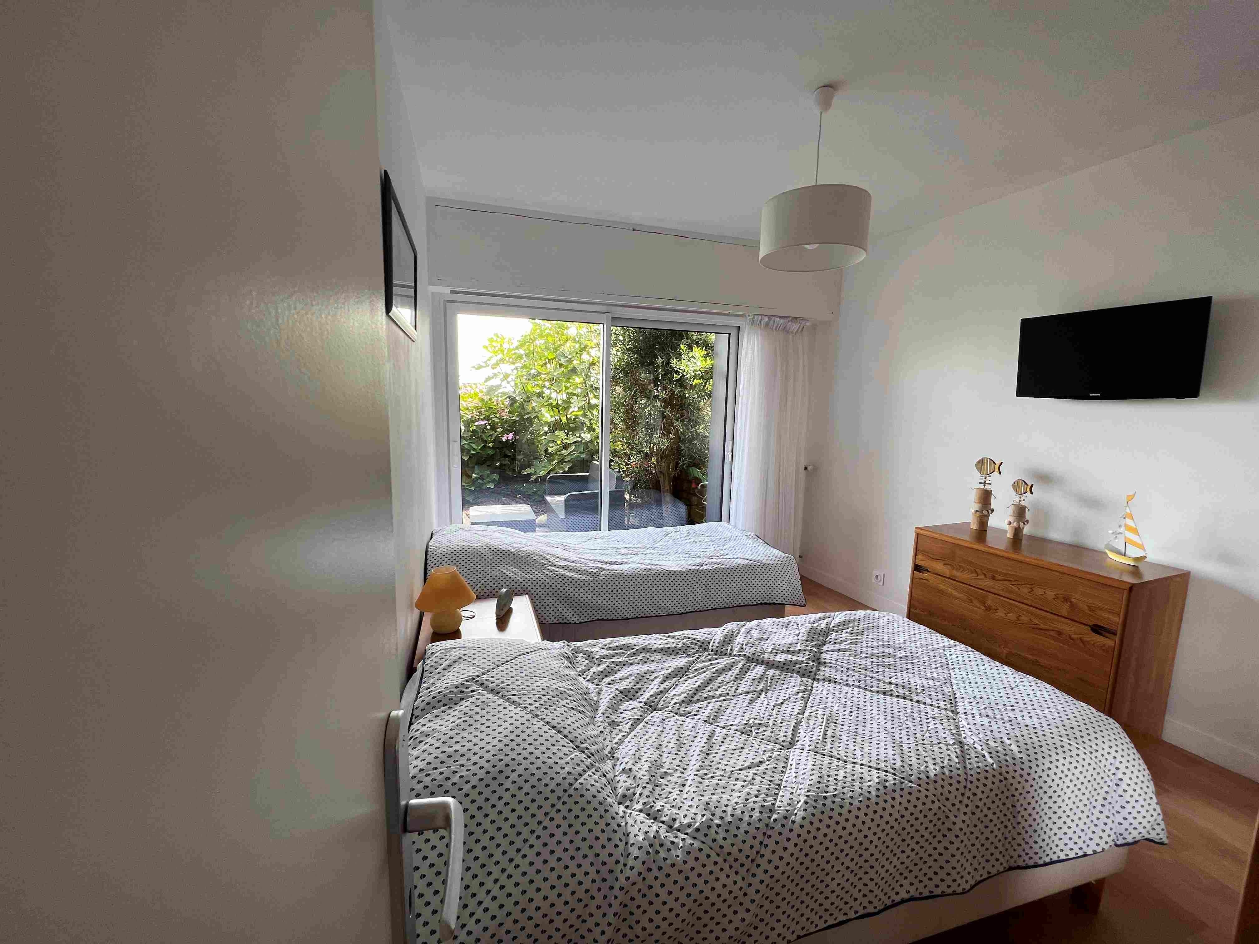 Une chambre donnant sur terrasse avec 2 lits 90 et TV
