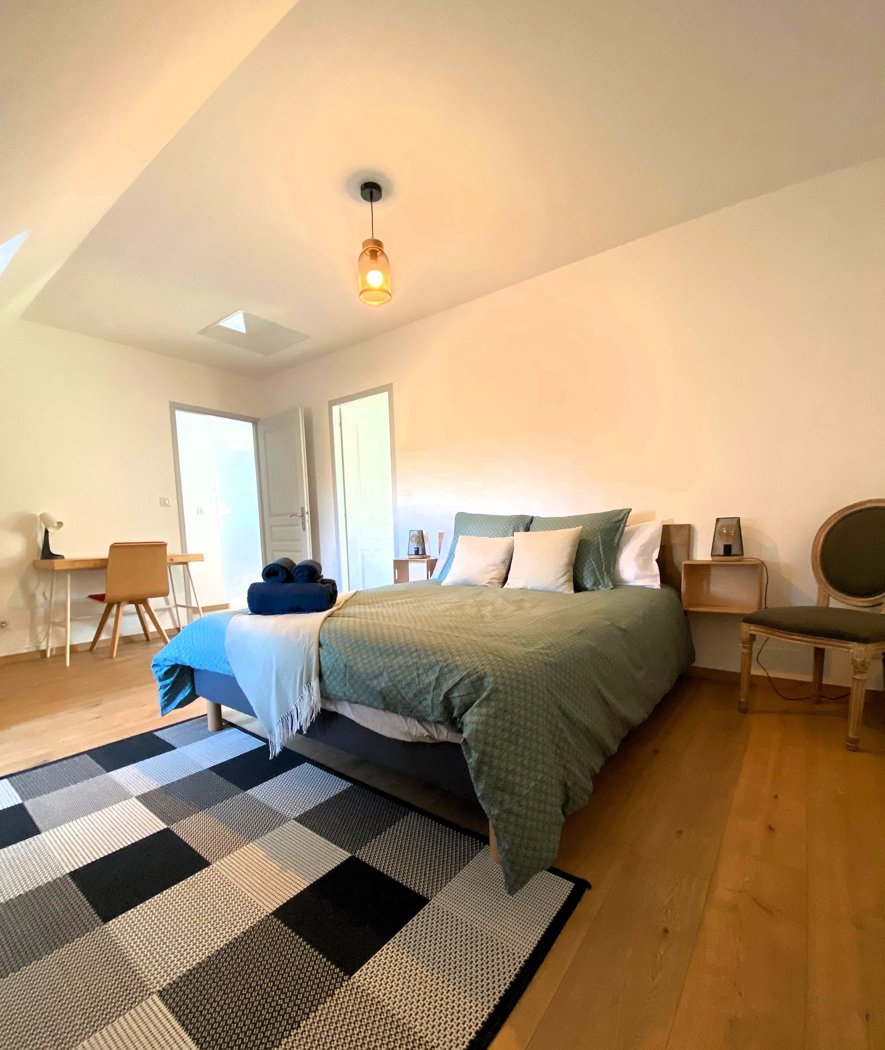 Chambre 2 à l'étage avec lit 160 cm, bureau et rangements. Salle d'eau communicante avec douche grande dimension et WC.
