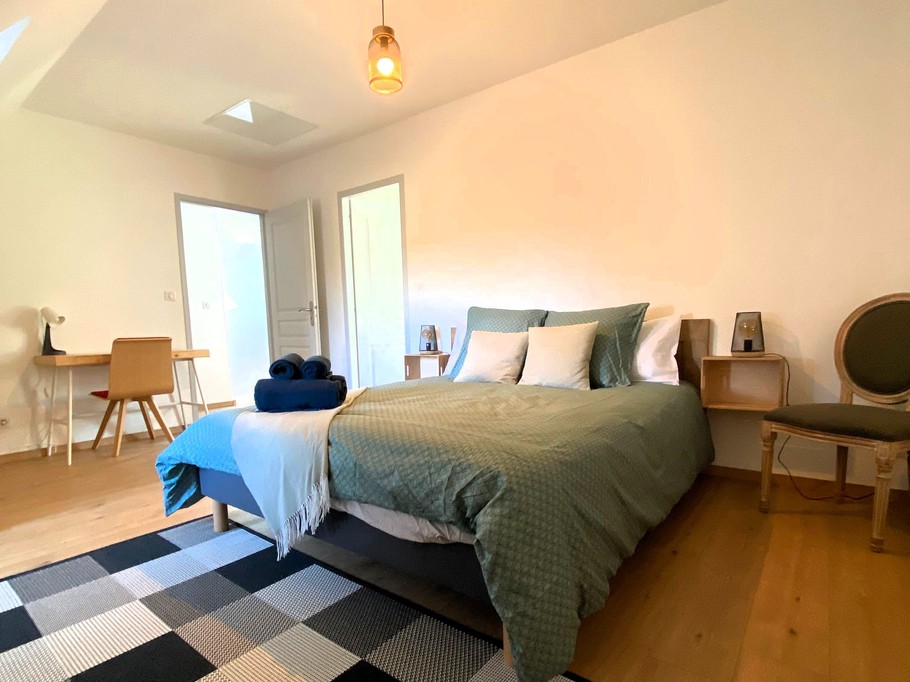 Chambre 2 à l'étage avec lit 160 cm, bureau et rangements. Salle d'eau communicante avec douche grande dimension et WC.